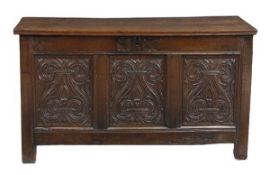 A Charles II panelled oak chest, circa 1660, above a triple panelled front, each panel carved with