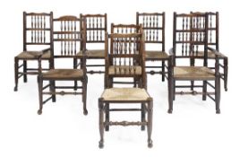 A matched set of eight ladderback chairs with rush seats, including two armchair, of typical form