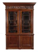 A mahogany bookcase, circa 1860 and later, the moulded cornice with a profusely carved frieze