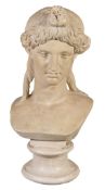 A painted plaster bust of a maiden, her hair tied up above her serene visage and falling in