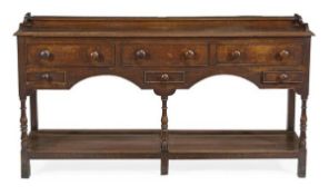 A George III dresser base, circa 1780, with an arrangement of five drawers above a potboard, on