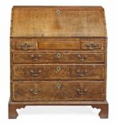 A George III walnut bureau, circa 1740 and later, the rectangular fall opening to small drawers