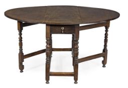 A Queen Anne walnut oval gateleg dining table, circa 1690, the top incorporating a pair of hinged