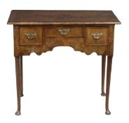 A George II walnut lowboy, circa 1750, with a rectangular top above three drawers and a shaped apron