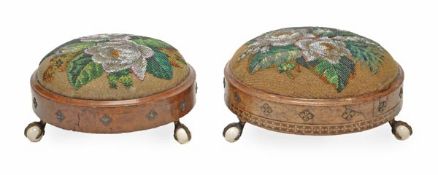 A matched pair of Victorian walnut and beadwork footstools, circa 1870, of circular form with floral