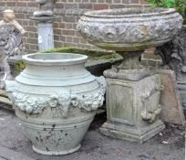 A reconstituted stone garden urn on plinth, 20th century, of shallow form with scrolling foliage