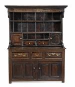 An oak North Wales canopy dresser, 17th century, with a plate rack incorporating shelves, two