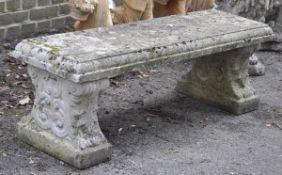 A reconstituted stone garden seat in 18th century style, 20th century, the rectangular top with