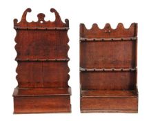 Two similar George III oak hanging spoon racks, circa 1760, each with shaped top above apertures for
