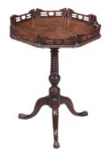 A George III mahogany octagonal tilt topped tripod table, circa 1780, with a pierced gallery, on a