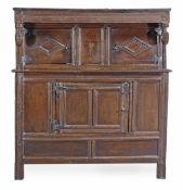 A Charles II oak press cupboard, circa 1660, the moulded cornice with stylised acorn pendant,