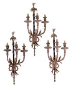 A set of three ebonised and gilt metal three light wall appliqués in the Louis XVI style, early 20th