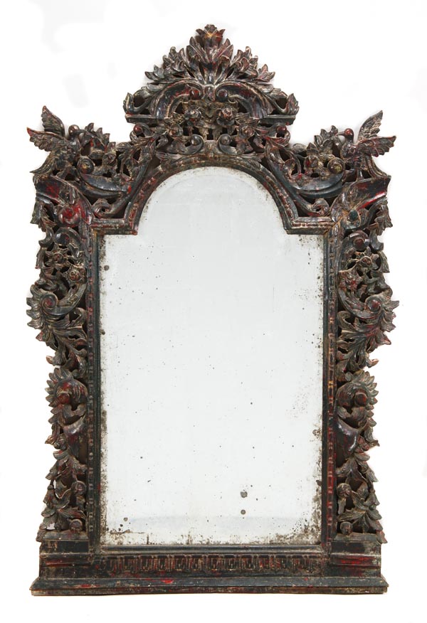 An Indian hardwood wall mirror, of recent manufacture, with a profusely carved crest and surround
