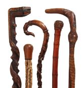 A Continental carved and stained wood, probably walnut walking stick, early 20th century, the