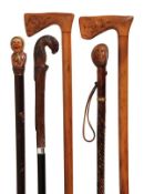 A Continental carved and stained wood mounted ebony walking stick, early 20th century, the grip