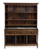 A George III oak dresser, circa 1780, with an open plate rack incorporating three shelves, the base