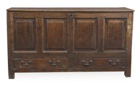 A George III oak mule chest, circa 1780, with a hinged top above a panelled front and drawers,