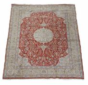 A Tabriz carpet, the oval central medallion within a navy field cornered by spandrels and