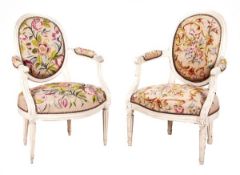 A pair of French painted cream and tapestry work upholstered open armchairs, late 19th/early 20th