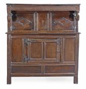 A Charles II oak press cupboard, circa 1660, the moulded cornice with stylised acorn pendant, above