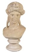 A painted plaster bust of a maiden, her hair tied up above her serene visage and falling in tresses
