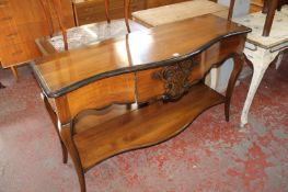 A cherrywood two tier serpentine side table with a frieze drawer 140cm wide