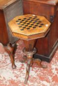 A Victorian walnut games/work table on facetted tapering column and carved tripod legs 47cm wide