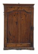 A George III oak hanging cupboard, circa 1780, the moulded cornice above a panelled cupboard door