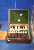 A bone and red stained chess set in mahogany box, king 10cm high