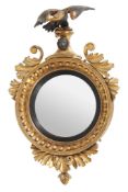 A Regency convex wall mirror, circa 1810, gilded and ebonised on gesso and wood  A Regency convex