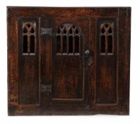 A late Gothic oak mural cupboard, English circa 1550 the central door with...  A late Gothic oak