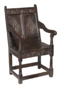 A Charles II oak panel back armchair circa 1660 with pointed finials and...  A Charles II oak panel