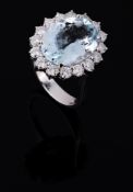 An aquamarine and diamond cluster ring, the central oval shaped aquamarine...  An aquamarine and