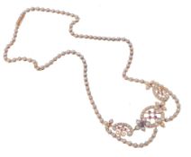 A half pearl and ruby necklace, the central openwork scrolled panel set with...  A half pearl and