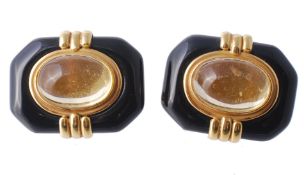 A pair of citrine and onyx ear clips, the central collet set oval cabochon...  A pair of citrine and