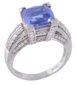 A tanzanite and diamond ring, the central fancy cut square shaped tanzanite in a four claw