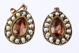 A pair of topaz and seed pearl ear pendents, the central foil backed pear shaped topaz within a