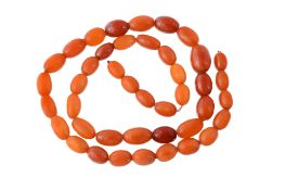 A graduated amber bead necklace, the forty three oval amber beads measuring...  A graduated amber