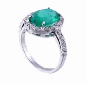 An emerald and diamond ring, the oval cut emerald estimated to weigh 4  An emerald and diamond ring