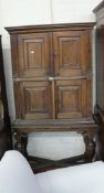 An oak 19th Century cabinet with panelled doors raised on bulbous turned supports.