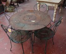 A wrought iron circular garden table and a set four chairs