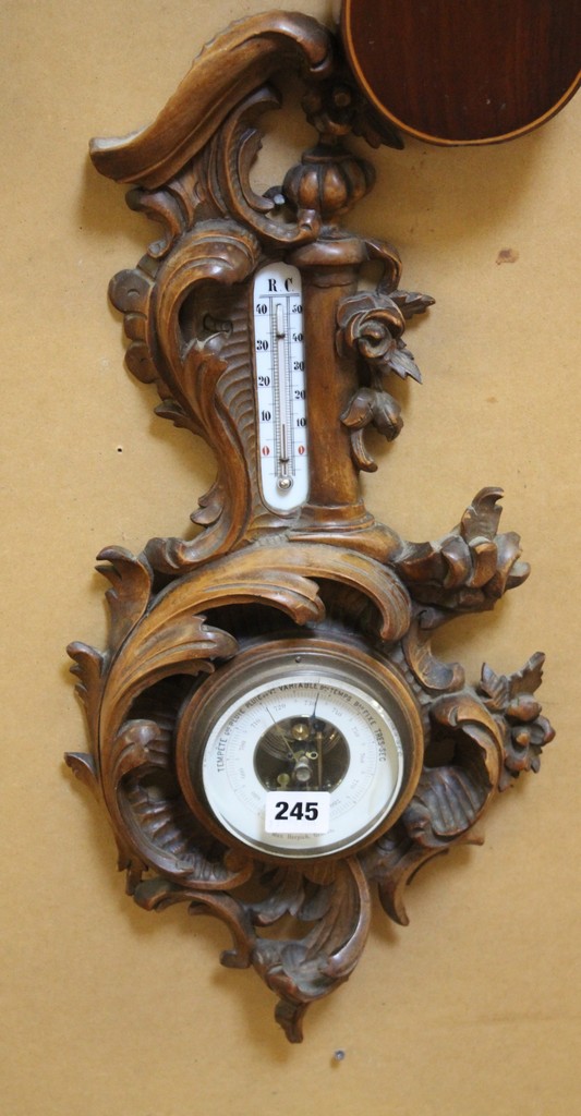 A Black forest carved wood aneroid wall barometer, late 19th century, with open-centred circular