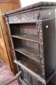 A Victorian oak bookcase circa 1870, carved throughout, with an arrangement of three open shelves