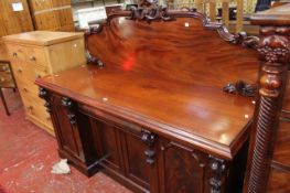 A Victorian mahogany pedestal sideboard, the arched rear gallery decorated with scroll motifs, the