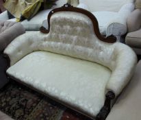 A Victorian walnut and button upholstered sofa the arched back incorporating sweeping arms with