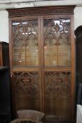 A Victorian oak gothic glazed two door bookcase, each door with two arched divisions.269cm h x 137.