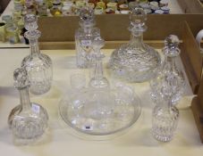 An etched glass decanter with six matching wines on a circular tray and six other assorted glass