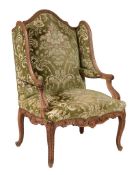 A carved beech high back armchair in French 18th century style, circa 1900, with arched