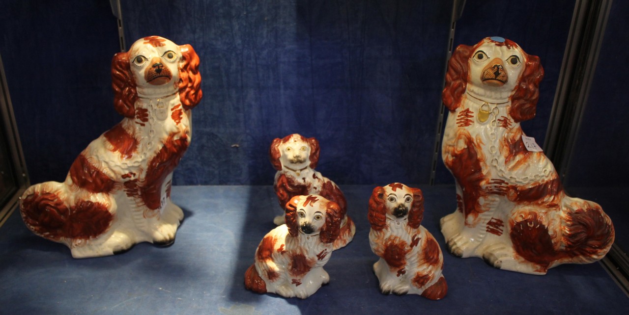 A pair of Staffordshire pottery spaniels, 31cm high and three smaller pottery spaniels 15cm high (5)