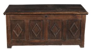 A Charles II oak chest circa 1660 hinged top above a quadruple panel front applied with lozenge